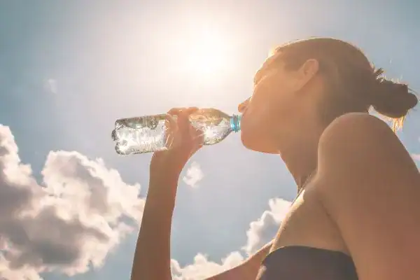 Hydration: The Secret Ingredient for a Toned Stomach and Enhanced Fitness 3 Image of woman drinking water to hydrate Herne after run.